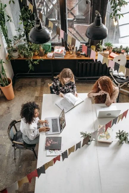 A creative workspace featuring UI design plans, pencils, a smartphone, and other office tools.